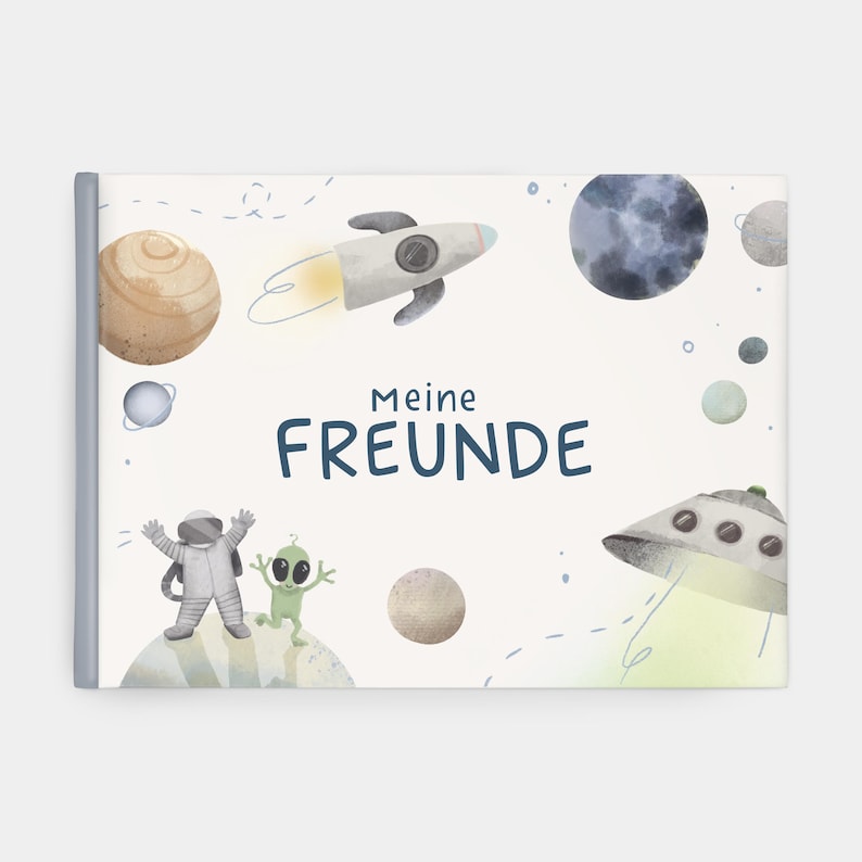 Op de afbeelding: Kinderboekcover met een ruimtethema. De cover toont een raket, planeten, een astronaut en een alien. De Duitse tekst "Meine FREUNDE" is in marineblauw weergegeven. De illustraties zijn in zachte aquareltonen.
