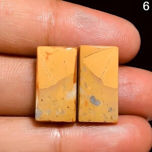 May include: Two rectangular pieces of yellow, brown, and white patterned stone. The stones have a rough, natural texture.
