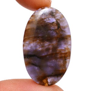 Peut inclure: Une pierre précieuse ovale en cabochon de couleur violette et brune avec un motif strié.