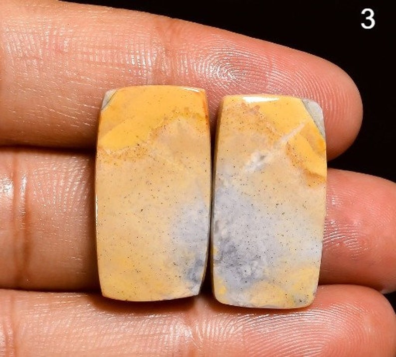 May include: Two rectangular yellow and grey gemstone cabochons with a mottled pattern.
