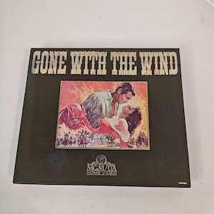 May include: A vintage "Gone With The Wind" VHS tape. The cover features the movie title in bold white letters above a colorful image of the film's stars. The MGM/UA Home Video logo is at the bottom.