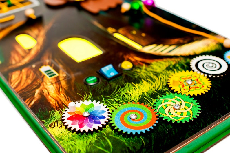 Pode incluir: Um brinquedo de madeira com design de casa na &aacute;rvore, com engrenagens coloridas, bot&otilde;es e uma janela que se ilumina. O brinquedo &eacute; projetado para que as crian&ccedil;as explorem e aprendam brincando.