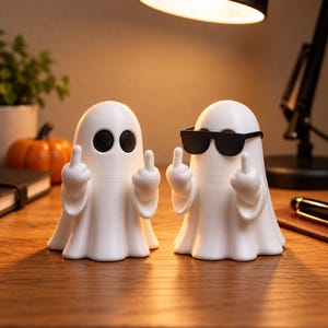 May include: Two white ghost figurines standing side by side. The left ghost has black circular eyes, while the right ghost wears black sunglasses. Both ghosts have arms raised with middle fingers extended in a gesture, featuring a smooth finish.