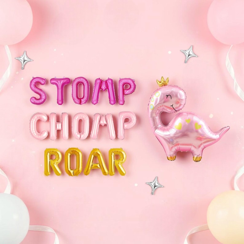 May include: Pink and gold foil balloons spelling "STOMP CHOMP ROAR" and a pink dinosaur balloon with a gold crown and heart accents, against a pink background. Silver star-shaped balloons and other pink balloons are also present.