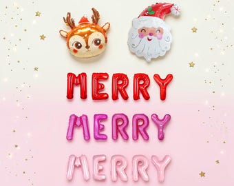May include: Foil balloons shaped like a reindeer head and a Santa Claus face positioned above three rows of letter balloons spelling MERRY in red, magenta, and light pink, surrounded by small gold star confetti on a gradient background.