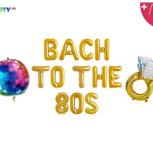 Op de afbeelding: Gouden folieballonnen met de tekst "BACH TO THE 80S", met een discobal-ballon en een diamanten ring-ballon. De discobal is veelkleurig. De ringballon heeft een witte en blauwe diamant.