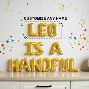 Op de afbeelding: Gouden folieballonletters met de tekst "LEO IS A HANDFUL" met daarboven de tekst "CUSTOMIZE ANY NAME". De achtergrond is wit met kleurrijke confetti en gouden slingers. Rechts staat een decoratieve papieren waaier.