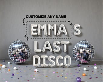 May include: Silver foil letter balloons spelling "EMMA'S LAST DISCO" with two disco ball balloons. The text "CUSTOMIZE ANY NAME" is above the name. Confetti and small decorative balls are scattered on the floor.
