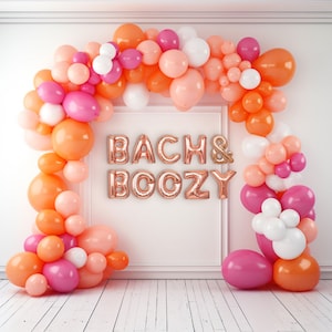 Peut inclure: Une arche de ballons festive aux tons orange, rose et blanc, encadrant les mots "BACH & BOOZY" en ballons lettres dorés métalliques. L'ensemble est posé contre un mur et un sol blancs, parfait pour une fête.