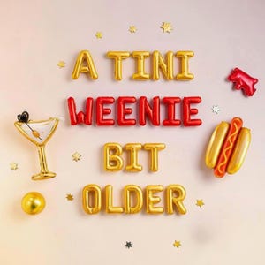 Puede incluir: Decoración festiva con globos de aluminio dorados y rojos que deletrean "A Tini Weenie Bit Older". Incluye una copa de martini dorada, globos de perritos calientes y confeti en forma de estrella. Ideal para un cumpleaños.