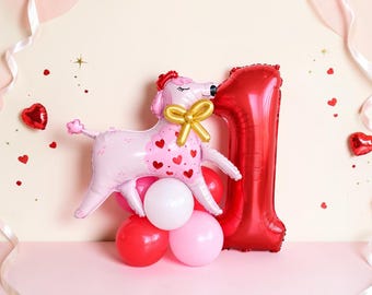 May include: A foil balloon shaped like a light pink poodle with a gold bow and red heart patterns, positioned next to a large red foil balloon in the shape of the number one, all resting on a cluster of small red, white, and pink balloons.