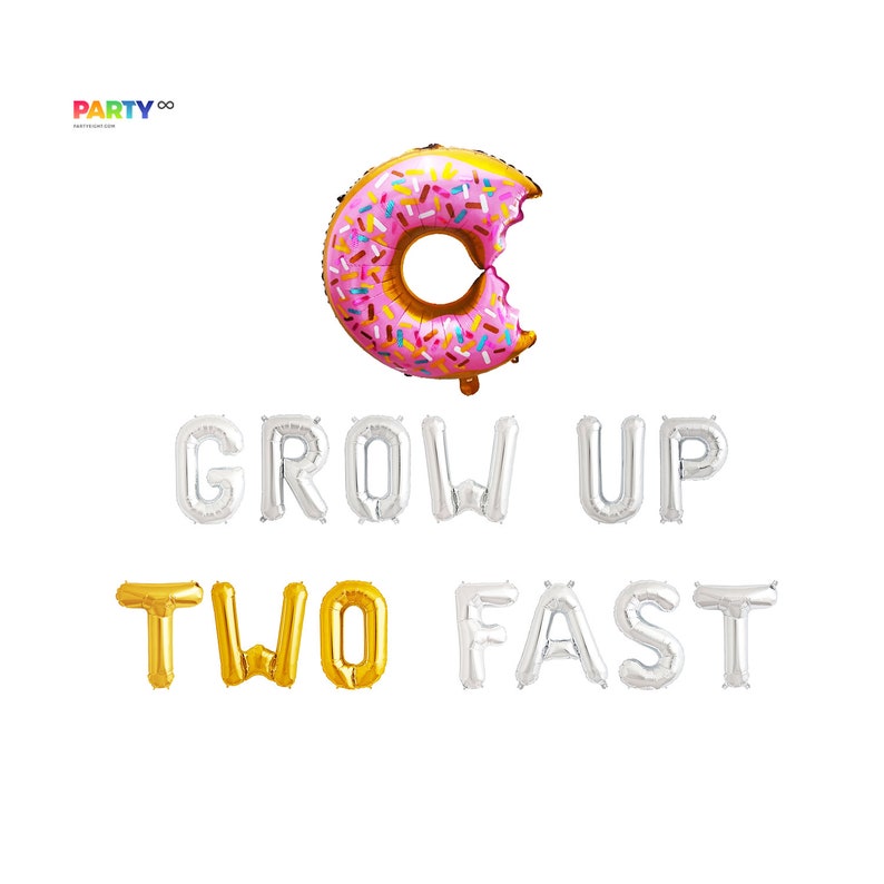 May include: A pink and gold donut-shaped balloon with a bite taken out of it, and the phrase "GROW UP TWO FAST" spelled out in silver and gold foil balloons. Party decor.