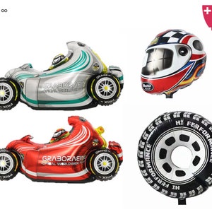 May include: A set of four foil balloons featuring a red and silver race car, a black and white tyre, and a red, white, and blue racing helmet. The balloons are all inflated and ready to be used for a party or celebration.