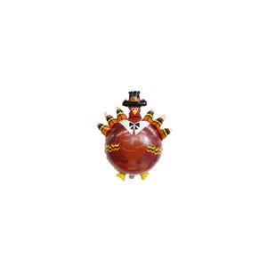 May include: A Thanksgiving-themed balloon shaped like a turkey. The turkey has a brown body, orange and yellow feathers, and a black pilgrim hat. It is wearing a white bow tie and a black tuxedo.