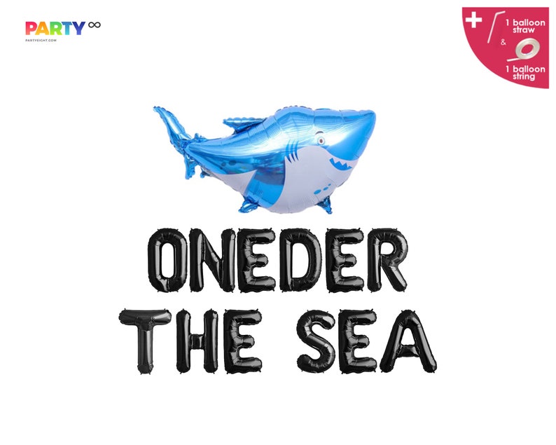 May include: A blue shark-shaped foil balloon with a white belly and a smiling face. Below the balloon, black letter balloons spell out "ONEDER THE SEA". Includes a balloon straw and string.
