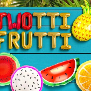May include: A vibrant image featuring the words "TWOTTI FRUTTI" in red and gold foil balloon letters. The image also includes fruit-shaped balloons: a pineapple, watermelon, dragon fruit, and orange, all against a blue background.