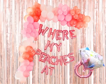 Può includere: Un set di decorazioni per feste con un arco di palloncini nei toni del rosa e pesca, con la scritta "WHERE MY PEACHES AT" in palloncini di alluminio rosa. È incluso anche un palloncino a forma di anello con diamante, il tutto su uno sfondo oro rosa.