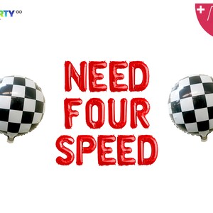 May include: Red foil balloons spell out "NEED FOUR SPEED" with two checkered flag balloons on either side. The balloons are for a party or celebration with a racing theme.