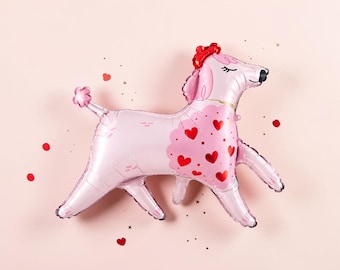 May include: A light pink poodle-shaped foil balloon featuring a red heart pattern on the chest, a red bow on the head, and a small pom-pom tail. The poodle has closed eyes with eyelashes and a black nose, surrounded by small red heart and star confetti.