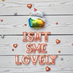 May include: A festive arrangement featuring a cake-shaped balloon with rainbow colors and the phrase "ISN'T SHE LOVELY" spelled out in rose gold letter balloons. Accented with heart and star-shaped decorations.