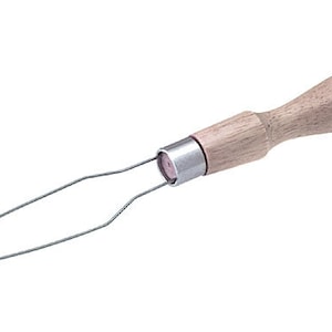 May include: A wooden handled tool with a metal loop at the end. The loop is designed to help pull yarn through a knitting needle.