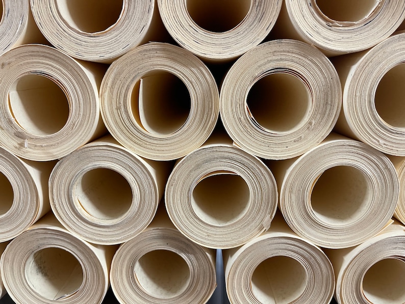 Op de afbeelding: Close-up van een stapel opgerolde witte papier, die lijkt op een verzameling buizen of cilinders.