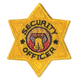 May include: A yellow embroidered star-shaped patch with the words "SECURITY OFFICER" in black lettering around a central image of a bell with three stars above it.