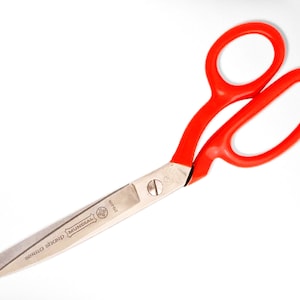 May include: Red handled scissors with a silver blade. The blade is marked "MUNDIAL" and "super sharp".