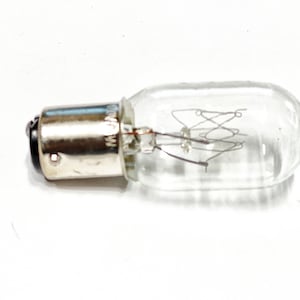 May include: A clear glass light bulb with a silver metal base and a coiled filament inside.