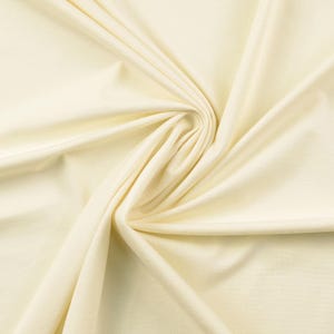 May include: Creamy white fabric with a soft, smooth texture. The fabric is draped and folded, creating a flowing, elegant look.