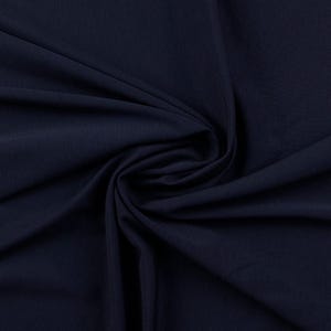 May include: A close-up of a dark blue fabric with a smooth texture. The fabric is folded and draped, showing its soft and flowing nature.