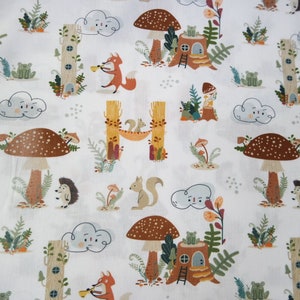 May include: White fabric with a repeating pattern of woodland creatures, mushrooms, and trees. The pattern includes squirrels, hedgehogs, foxes, frogs, and clouds. The fabric is ideal for crafting projects such as quilts, cushions, and tote bags.