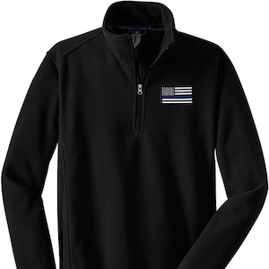 May include: Black fleece pullover with a zipper and a thin blue line American flag patch on the left chest.