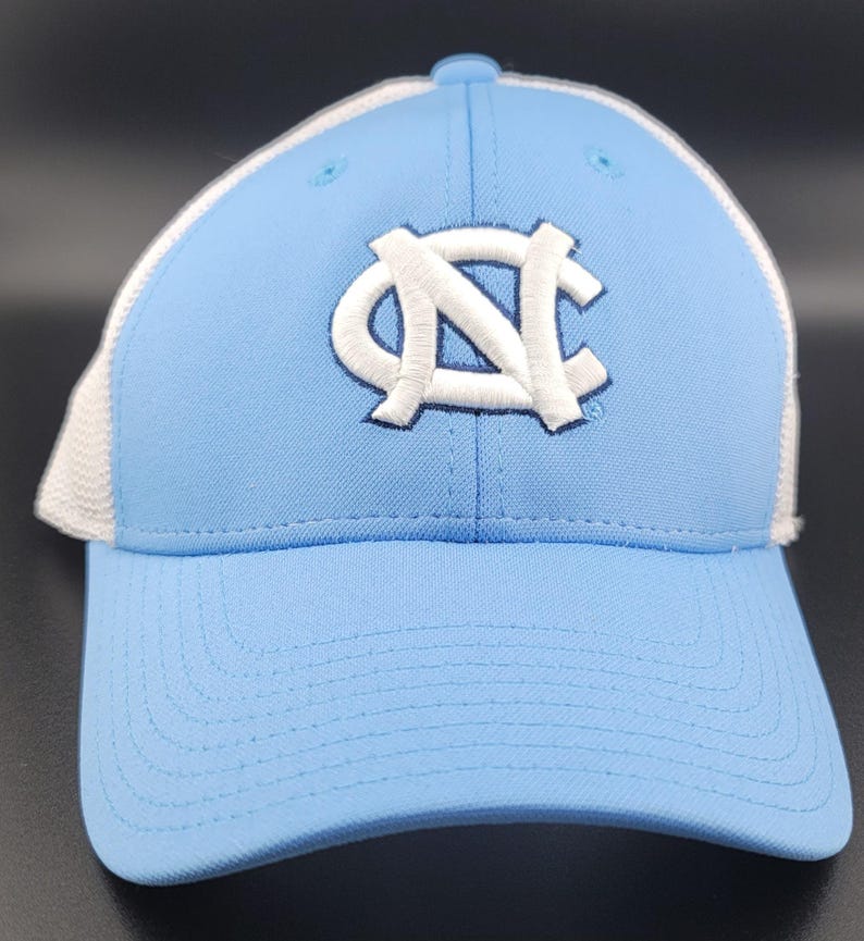 May include: A light blue baseball cap with a white mesh back and a white embroidered "NC" logo.