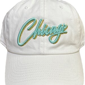 May include: White baseball cap with a green and gold embroidered "Chicago" logo.