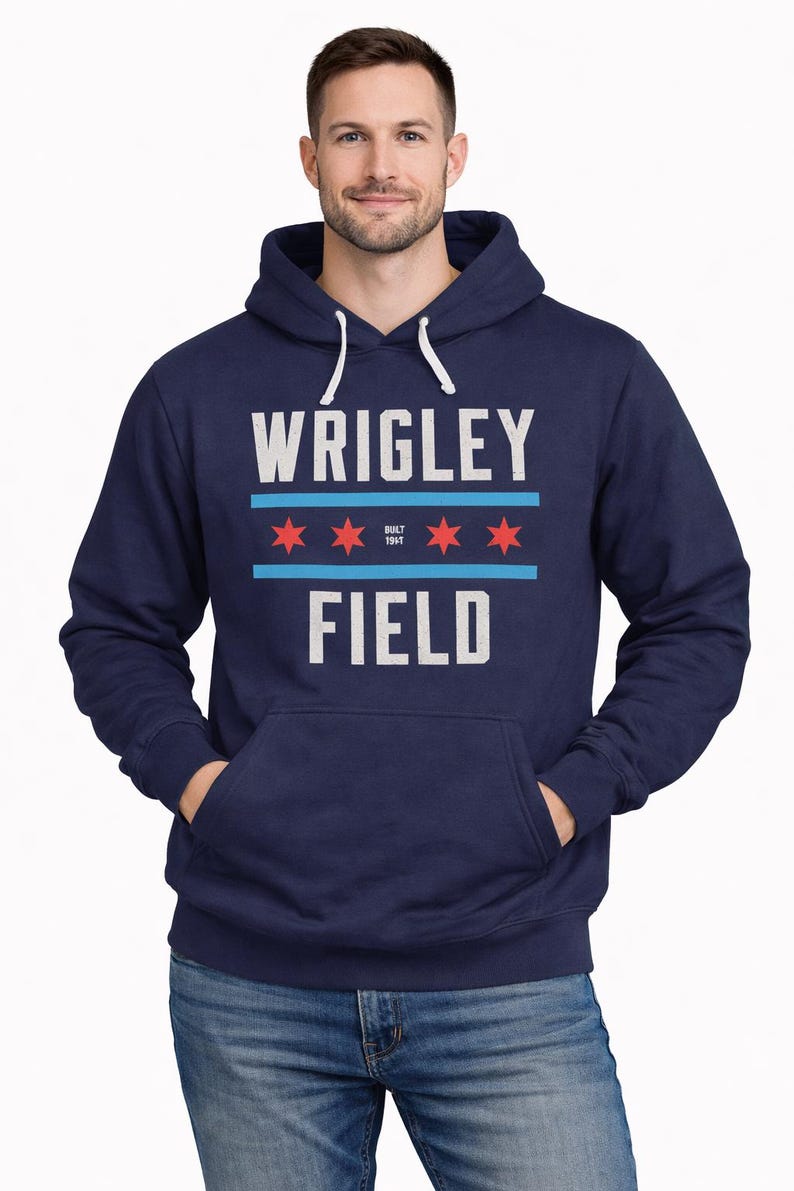 May include: Navy blue hoodie with the text "WRIGLEY FIELD" in white block letters. Above the text are two horizontal blue lines and three red stars. The hoodie has a front pocket and a white drawstring.