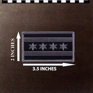 May include: Embroidered patch of the Chicago flag. The flag is black and white with six white stars on a white stripe. The patch is 3.5 inches wide and 2 inches tall.