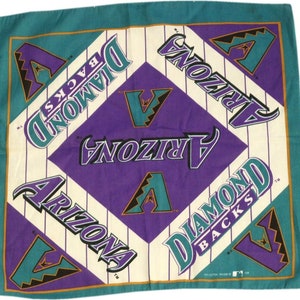 May include: A purple and teal bandana with the Arizona Diamondbacks logo. The logo is repeated four times on the bandana, with the words "Arizona Diamondbacks" written in a curved font.