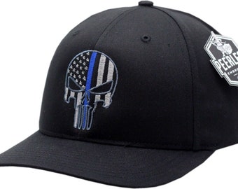 May include: Black baseball cap with a blue line American flag and a skull graphic. The cap has a curved brim and is embroidered with the text "Peerless Embroidery Co."