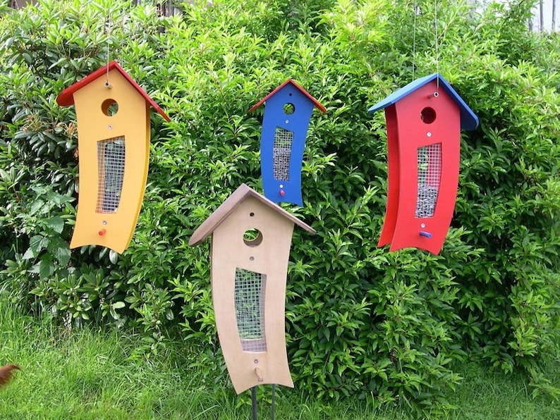 Puede incluir: Cuatro comederos para p&aacute;jaros, cada uno con un esquema de colores diferente. Los comederos tienen forma de casa con un frente curvo y una abertura de malla para que los p&aacute;jaros puedan acceder a la comida. Los colores son amarillo, azul, rojo y marr&oacute;n.
