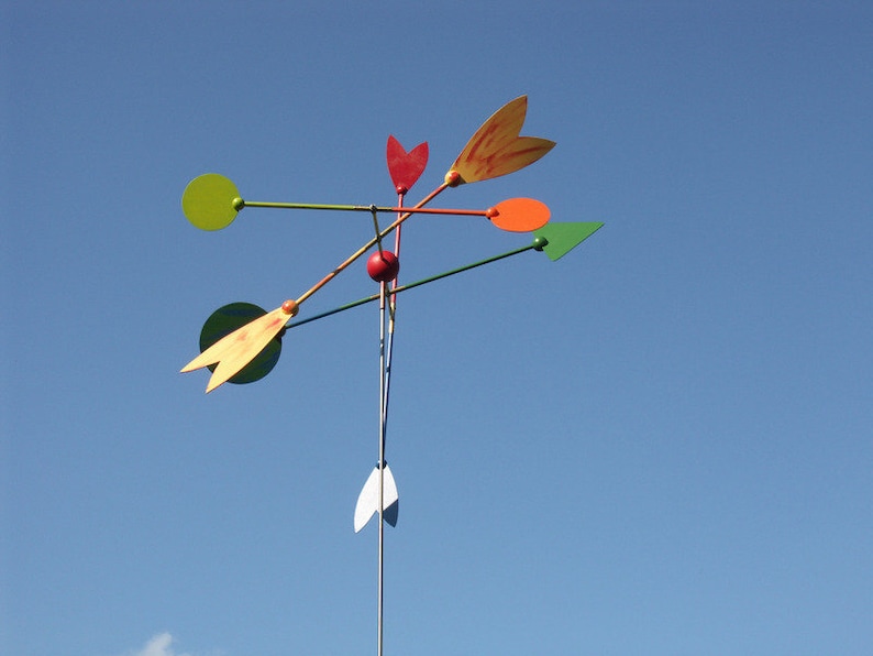 May include: A colorful metal mobile with red, orange, yellow, and green shapes. The mobile is suspended from a metal rod and spins in the wind.