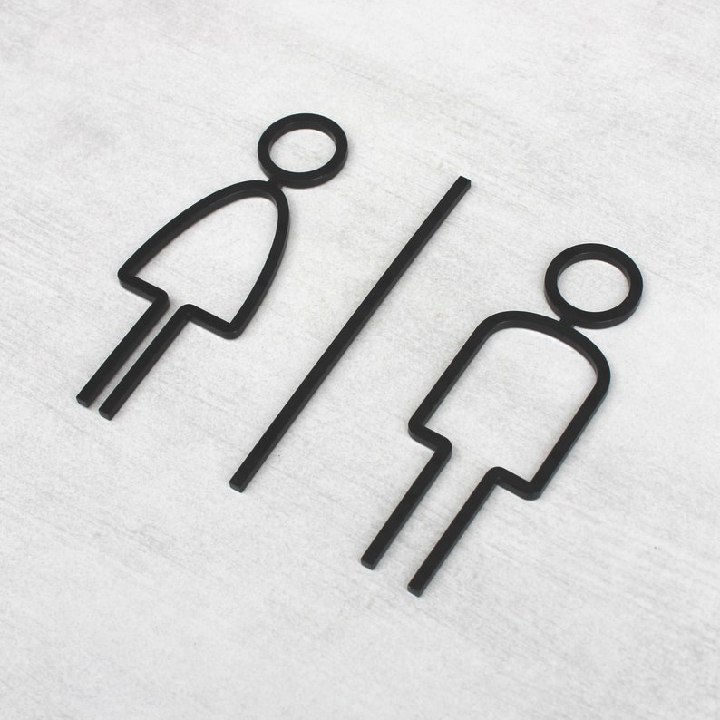 Puede incluir: Esquema en blanco y negro de un s&iacute;mbolo de ba&ntilde;o masculino y femenino sobre un fondo blanco.