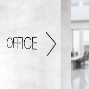 May include: A white wall with the word "OFFICE" and a black arrow pointing to the right.