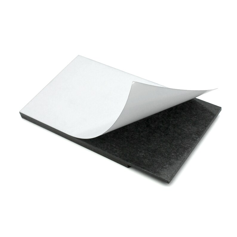 May include: A black adhesive-backed magnetic sheet with a white adhesive backing peeled back to reveal the magnetic surface.