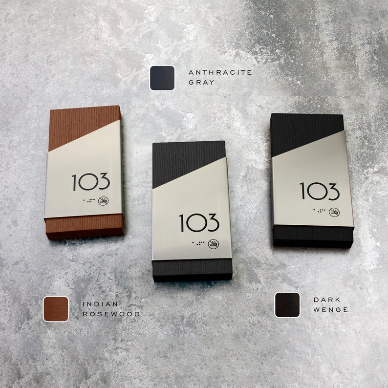 May include: Three door number signs with a silver metal plate and black numbers. The signs are made of different wood finishes: Indian Rosewood, Dark Wenge, and Anthracite Gray.