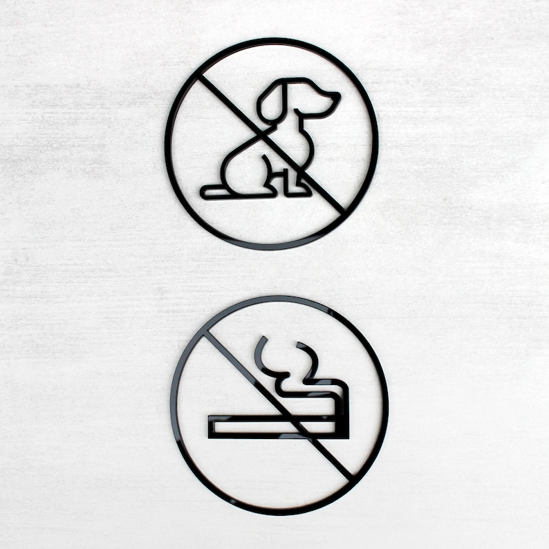 May include: Two black and white signs with a diagonal line through them. The top sign has a silhouette of a dog and the bottom sign has a silhouette of a cigarette.