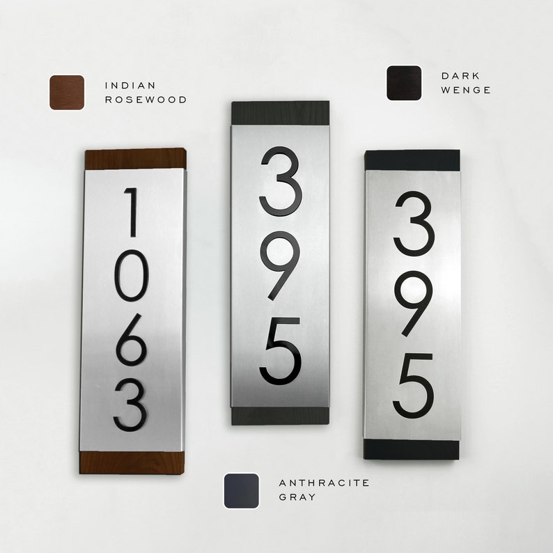 May include: Three silver house number plaques with black numbers. The numbers are 1063, 395, and 395. The plaques have different colored frames: Indian Rosewood, Dark Wenge, and Anthracite Gray.