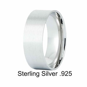 May include: A sterling silver ring with a brushed finish. The ring has a wide band and a polished interior. The text "Sterling Silver .925" is printed below the ring. This ring is a piece of jewelry.