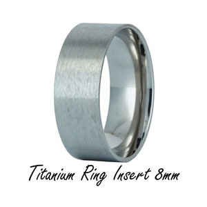 May include: A brushed titanium ring insert, 8mm wide. The ring is a simple, modern design.