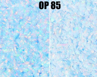 May include: Close-up of iridescent blue opal glitter, showing the glitter wet and dry. The glitter is labelled "OP 85".